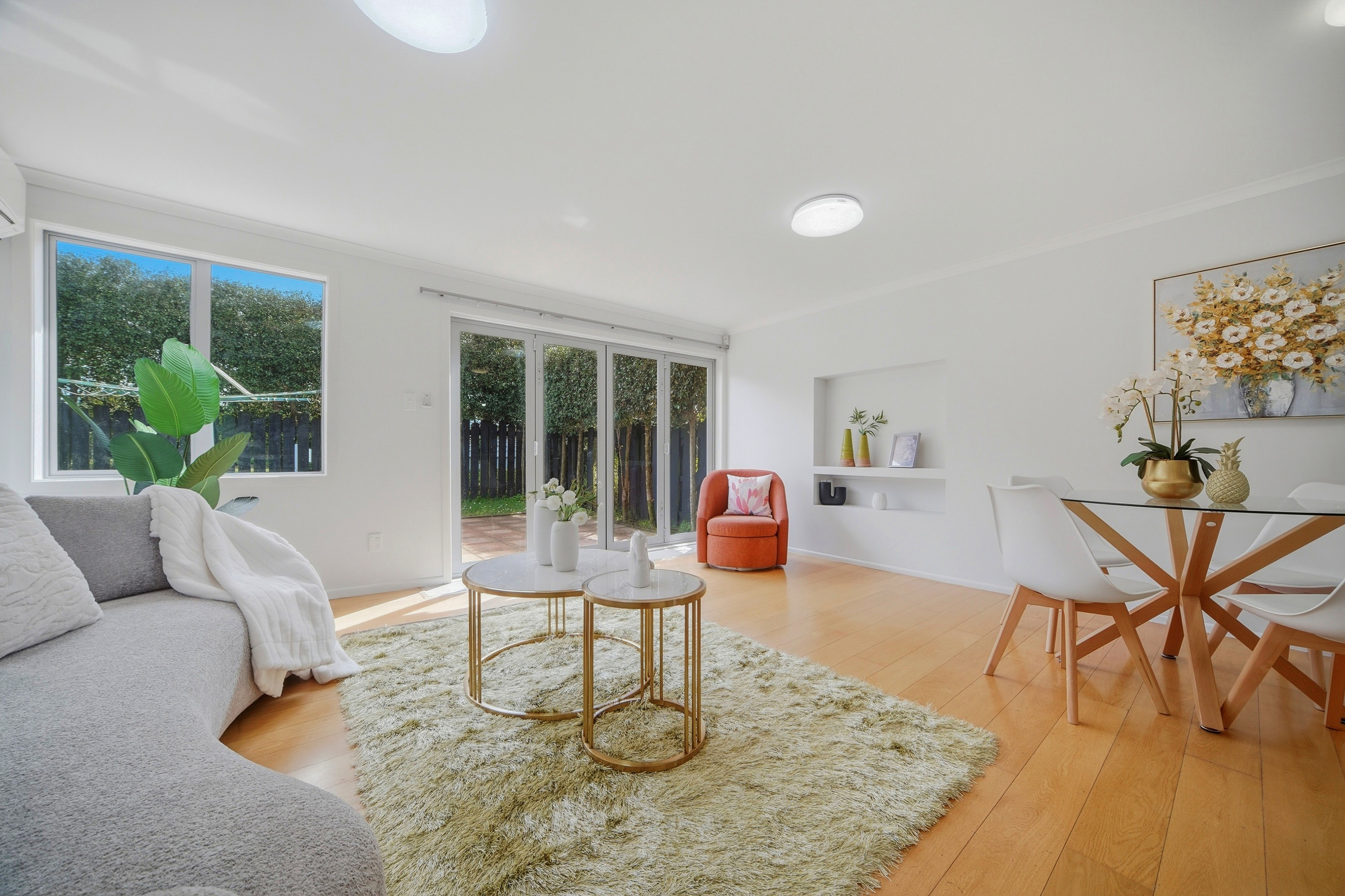 4-bedroom Townhouse at 7a Atherton Road, Epsom. Open-plan living area with hardwood floors, sliding glass doors leading to a patio, and a built-in wall niche.